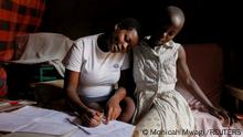 Secondary school student Jackline Bosibori, 17, who is seven-months pregnant, helps her younger sister Angela Moraa, 12, with school work at their home in Lindi village within the Kibera slums in Nairobi, Kenya, September 30, 2020. With schools closed due to the coronavirus pandemic and Bosibori's mother out selling vegetables on the roadside, Bosibori got involved with a man in his twenties. When she told him she was pregnant, he stopped answering her calls. REUTERS/Monicah Mwangi TPX IMAGES OF THE DAY SEARCH KENYA LOCKDOWN PREGNANCIES FOR THIS STORY. SEARCH WIDER IMAGE FOR ALL STORIES.