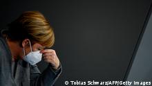 German Chancellor Angela Merkel adjusts her face mask during a session at the Bundestag (lower house of parliament) on November 18, 2020 in Berlin on measures to curb the spread of the novel coronavirus (COVID-19). (Photo by Tobias SCHWARZ / AFP) (Photo by TOBIAS SCHWARZ/AFP via Getty Images)