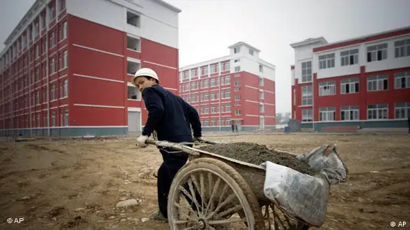 In this photo taken Friday, Feb. 5, 2010, a man works outside a school which is rebuilt after the 2008 earthquake in Beichuan, China. Just 22 months from the 7.9-magnitude quake struck, scarred mountain sides are often the only physical indication of the devastation that left nearly 90,000 dead or missing and another 5 million homeless. (AP Photo/Vincent Thian)