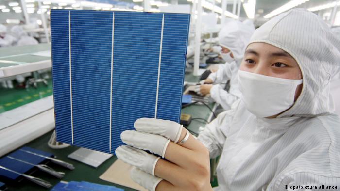 一名中国工人在伊欧普利新能源科技有限公司的工厂检查太阳能电池板的光伏电池。 位于华东江苏省南通市