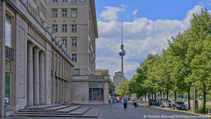 Bangunan di Karl Marx Alle dengan fasad bergaya beton brutal dan latar belakang menara TV di Berlin