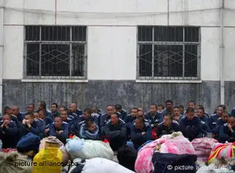 Prisoners wait to be transfered to a newly-built jail with their belongings in Zhoukou in central China's Henan province, 10 April 2010. Over 600 inmates left the old Zhoukou Prison, the largest farm-jail in the province, for the new modern jail. EPA/ZHANG XIAOLI
