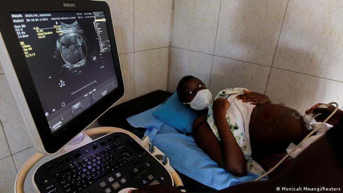 EIne hochschwangere junge Frau auf einer Liege, es wird ein Ultraschall gemacht