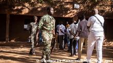 Security forces walk by voters queuing to vote at a polling station in Ouagadougou on November 22, 2020, during Burkina Faso's presidential and legislative elections. (Photo by OLYMPIA DE MAISMONT / AFP) (Photo by OLYMPIA DE MAISMONT/AFP via Getty Images)