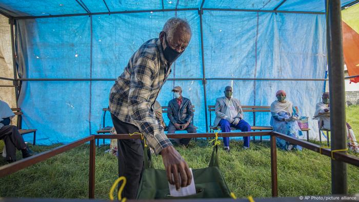 A man puts a ballot paper in a ballot box during the TPLF election