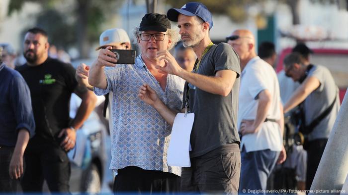 Regisseur Edoardo Ponti schaut mit dem Kameramann in ein Handy (IPA/Fotogramma/picture alliance).