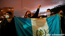 Demonstrators hold a Guatemalan flag during a protest to demand the resignation of Guatemalan President Alejandro Giammattei, in Guatemala City on November 23, 2020. - Guatemala's legislature on Monday backed away from approving a business-friendly 2021 budget after demonstrators in the Central American nation torched the Congress building and demanded the resignation of President Alejandro Giammattei in weekend protests. (Photo by Johan ORDONEZ / AFP)