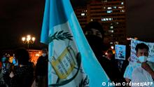 A demonstrator holds a Guatemalan flag during a protest to demand the resignation of Guatemalan President Alejandro Giammattei, in Guatemala City on November 23, 2020. - Guatemala's legislature on Monday backed away from approving a business-friendly 2021 budget after demonstrators in the Central American nation torched the Congress building and demanded the resignation of President Alejandro Giammattei in weekend protests. (Photo by Johan ORDONEZ / AFP)