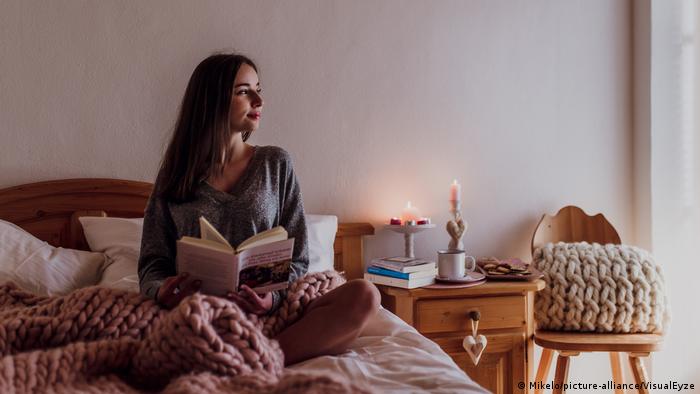 Woman sitting in bed with book