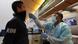 A healthcare worker tests a man at Los Angeles LAX airport A healthcare worker tests a man at Los Angeles LAX airport