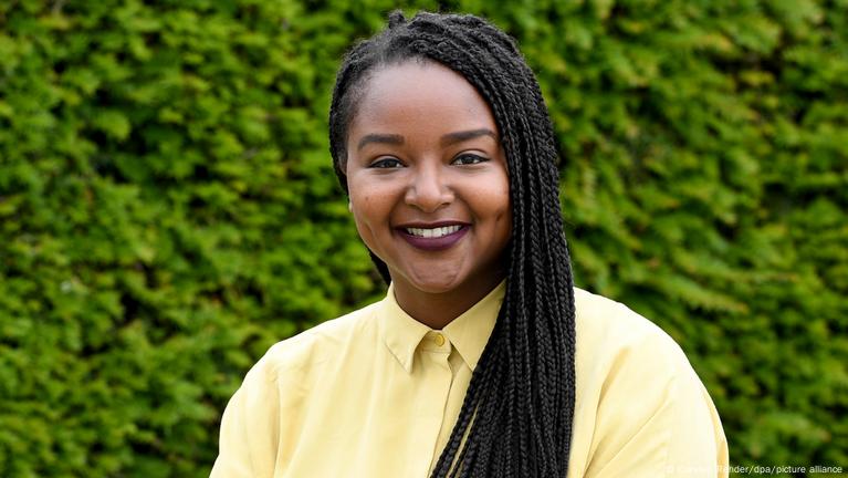 A happy black latin girl with green Box Braids hairstyle smiling