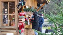 Two customers purchase cups of mulled wine at a special outdoor kiosk in Lindenthal, Cologne. November 27, 2020. 