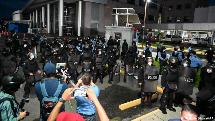 Foto de agentes antimotines frente a seguidores de Manuel Zelaya en el aeropuerto de Toncontín