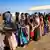 Ethiopian refugees from Tigray region stand in a line for food