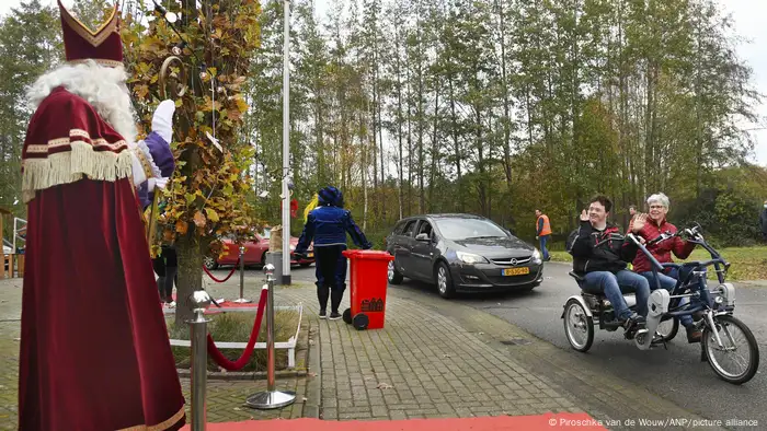 Bicycles and cars drive past waving Saint Nicholas, Vorden, Netherlands (ANP Piroschka van de Wouw)