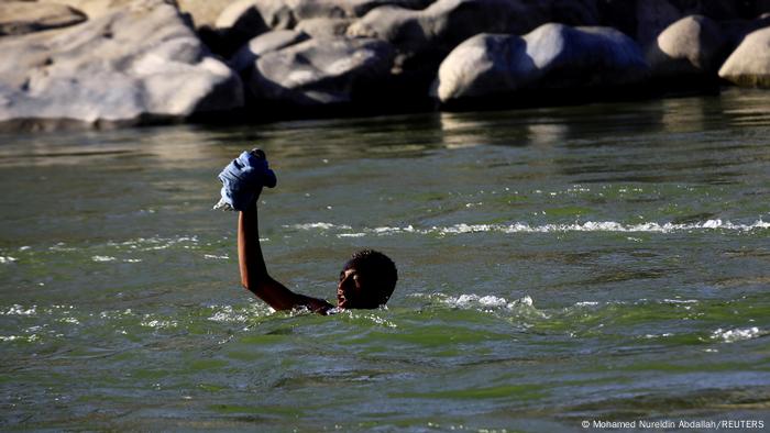 An Ethiopian crosses the Setit river on the Sudan-Ethiopia border in Hamdayet village