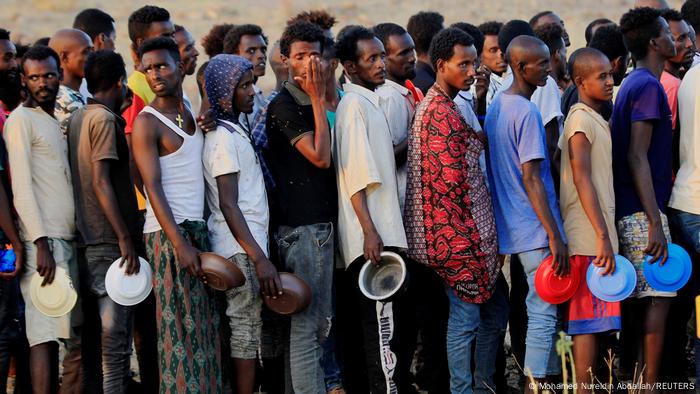Ethiopian men who fled war in Tigray region, queue for wet food ration at the Um-Rakoba camp, on the Sudan-Ethiopia border in Al-Qadarif state, Sudan November 19, 2020.
