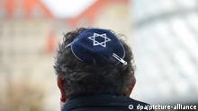 Auf einer Kundgebung gegen Antisemitismus in Leipzig trägt ein Teilnehmer eine Kippa.
