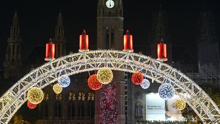 Candle arch with four Advent candles, in the background: Town Hall with Christmas tree, Vienna, Austria