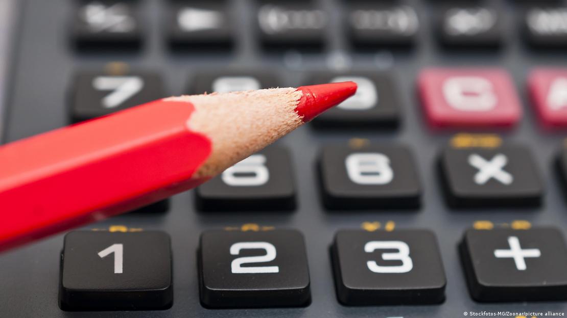 Lápis vermelho com teclado de calculadora ao fundo