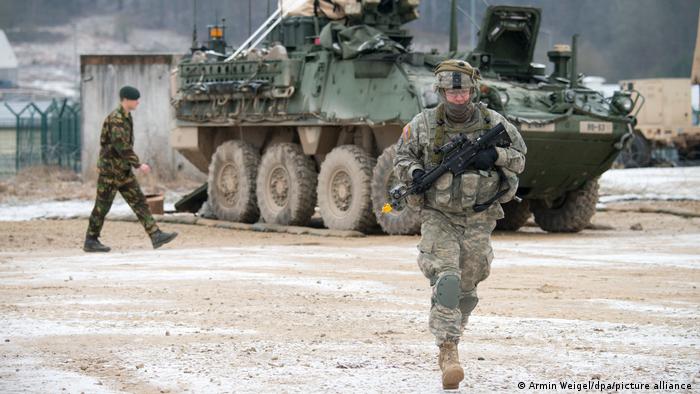 Arşiv - Almanya'nın Bavyera eyaletindeki Hohenfels askeri tatbikat alanında, Stryker tipi zırhlı aracın önünde yürüyen bir ABD askeri (eli silahlı olan) - (23.01.2015)