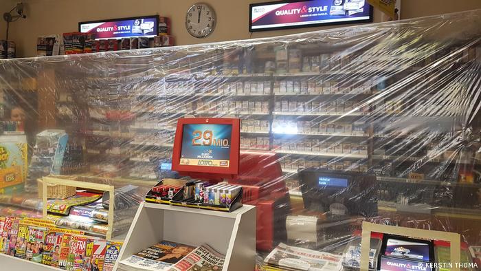 A kiosk with plastic wrap hanging in front of the cash register
