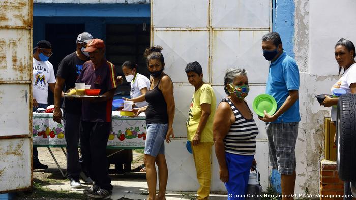 Voluntarios alimentan a necesitados con ayuda de comerciantes, en un barrio de Valencia, Carabobo, en Venezuela, uno de los países más desiguales de la región.