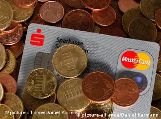 Einer Kreditkarte liegt in einem Haufen von Cent-Münzen verschiedener Wertigkeiten, aufgenommen am 24.01.2010. Foto: Daniel Karmann dpa/lby