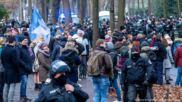 Police stand between anti-lockdown protesters and counter-demonstrators in Bremen, Germany
