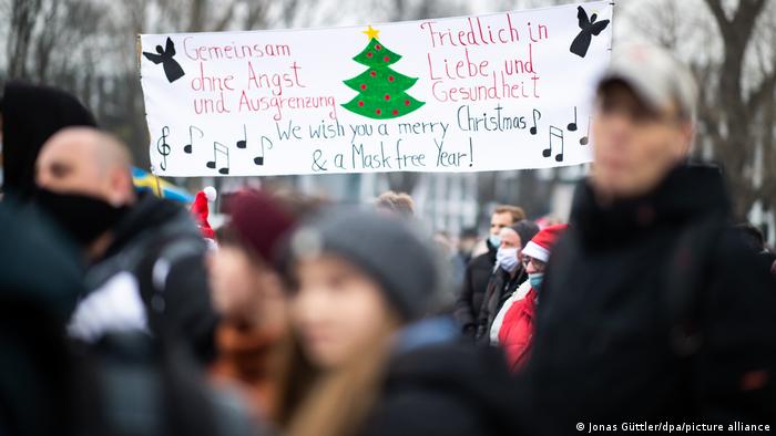 Anti-lockdown protesters in Düsseldorf with a banner saying: We wish you a merry Christmas and a mask free year