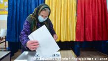 An elderly woman casts her vote in the village of Sabareni, Romania, Sunday, Dec. 6, 2020. Voting started in Romania's legislative election expected to restore some measure of stability after five years of political and social turbulence with more than 18 million Romanians registered to vote for a new legislative body. (AP Photo/Alexandru Dobre)