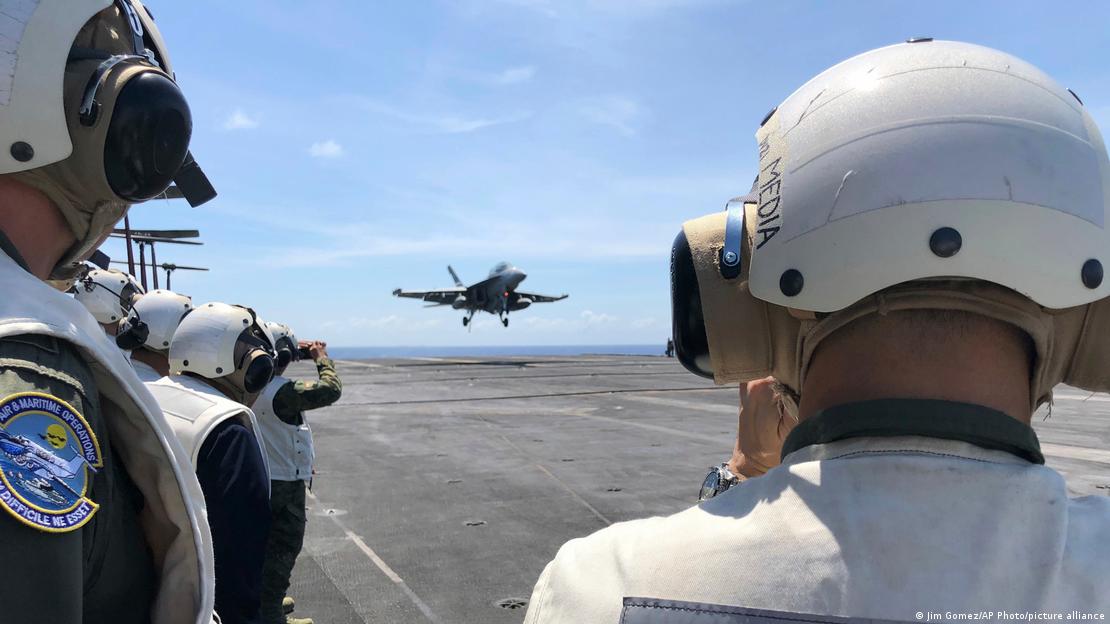 مشاہدین امریکی طیارہ بردار بحری جہاز تھیوڈور روزویلٹ کے ڈیک سے یہ منظر دیکھ رہے ہیں جب ایک امریکی ایف-18 لڑاکا طیارہ لینڈ کر رہا ہے مشاہدین امریکی طیارہ بردار بحری جہاز تھیوڈور روزویلٹ کے ڈیک سے یہ منظر دیکھ رہے ہیں جب ایک امریکی ایف-18 لڑاکا طیارہ لینڈ کر رہا ہے