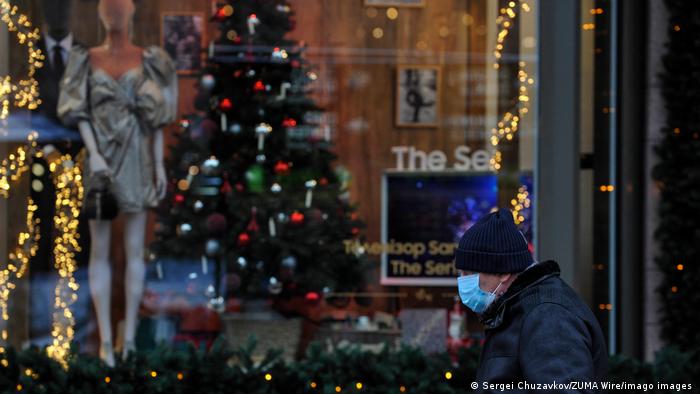 Чоловік у масці на тлі новорічних декорацій у Києві (архівне фото)