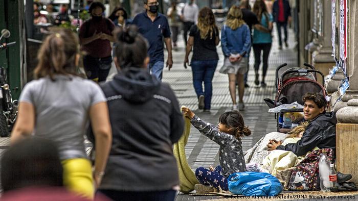 Mendigas en una calle de Buenos Aires con numerosos transeúntes.