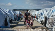 14.10.2020 Migrants walk after a rainstorm at the Kara Tepe refugee camp, on the northeastern Aegean island of Lesbos, Greece, Wednesday, Oct. 14, 2020. Around 7,600 refugees and migrants have settled at the new tent city after successive fires on Sept. 9, devastated the Moria refugee camp, making thousands of inhabitants homeless during a COVD-19 lockdown. (AP Photo/Panagiotis Balaskas)