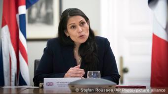 UK Home Secretary Priti Patel sitting behind a desk