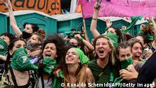 Demonstrators celebrate with green headscarves - the symbol of pro-abortion activists - outside the Argentine Congress in Buenos Aires on December 11, 2020, after legislators passed a bill to legalize abortion. (Photo by RONALDO SCHEMIDT / AFP) (Photo by RONALDO SCHEMIDT/AFP via Getty Images)
