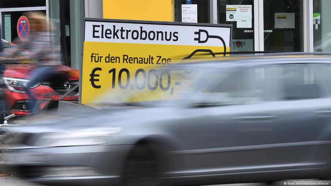 Almanya'da elektrikli otomobillere yönelik 10 bin euroluk teşviki duyuran "Elektrobonus" tabelasının önünden bir otomobil geçiyor.