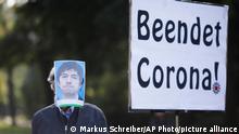 01.10.2020 *** A man has covered his face with a photo of virologist and government advisor Christian Drosten, during a protest of people against the government's coronavirus policy in front of German President's residence Bellevue Palace in Berlin, Germany, Thursday, Oct. 1, 2020. German President Frank-Walter Steinmeier honours about 15 people with the Orders of Merit, the highest award from German government, including people helping to fight the virus outbreak. The poster reads: ‚Ends Corona' (AP Photo/Markus Schreiber)