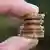 A hand holding several euro coins