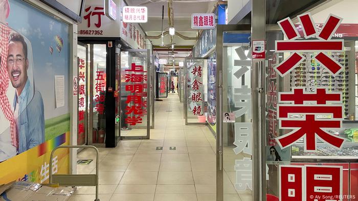 An empty corridor with shops open on either side.