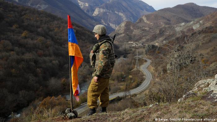 Армянский военнослужащий у флага непризнанной Нагорно-Карабахской республики возле села Чаректар в Нагорном Карабахе