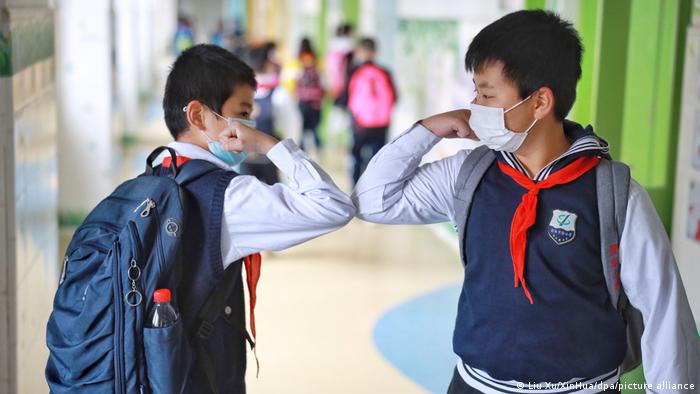Coronavirus - China Schüler grüßen mit Ellenbogen