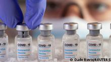 FILE PHOTO: Woman holds vials labelled COVID-19 Coronavirus Vaccine over dry ice in this illustration taken, December 5, 2020. REUTERS/Dado Ruvic/Illustration/File Photo