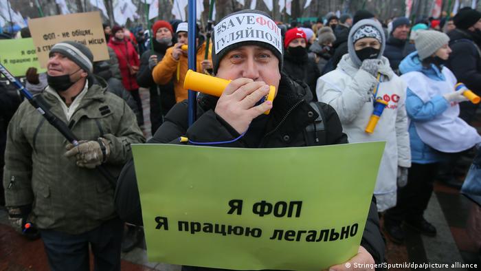 a protester holds up a yellow sign