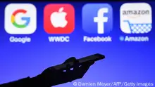 This photograph taken on September 28, 2017, shows a smartphone being operated in front of GAFA logos (acronym for Google, Apple, Facebook and Amazon web giants) as background in Hédé-Bazouges, western France. / AFP PHOTO / Damien MEYER (Photo credit should read DAMIEN MEYER/AFP via Getty Images)