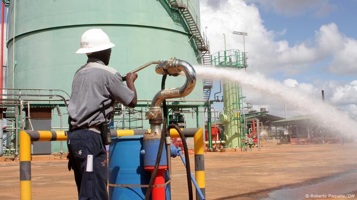 A gas worker works on open water pipe.