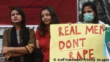 A demonstrator holds a placard next to others during a protest against an alleged gang rape of a woman, in Karachi on September 18, 2020. - Hundreds of women have taken to the streets of cities across Pakistan in recent days after a woman was raped in front of her two children when her car ran out of fuel near the eastern city of Lahore. (Photo by Asif HASSAN / AFP) (Photo by ASIF HASSAN/AFP via Getty Images)