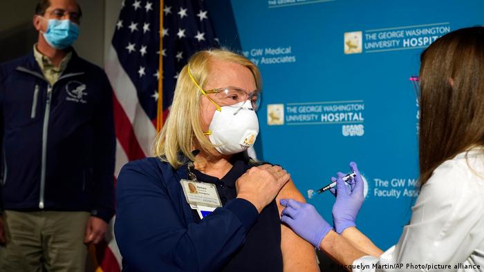 A enfermeira Lillian Wirpsza administra uma vacina de covid-19 na enfermeira Barbara Neiswander, do departamento de emergência, no Hospital Universitário George Washington, em 14 de dezembro de 2020, em Washington