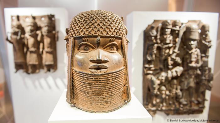 A bronze sculpture of a face with headress